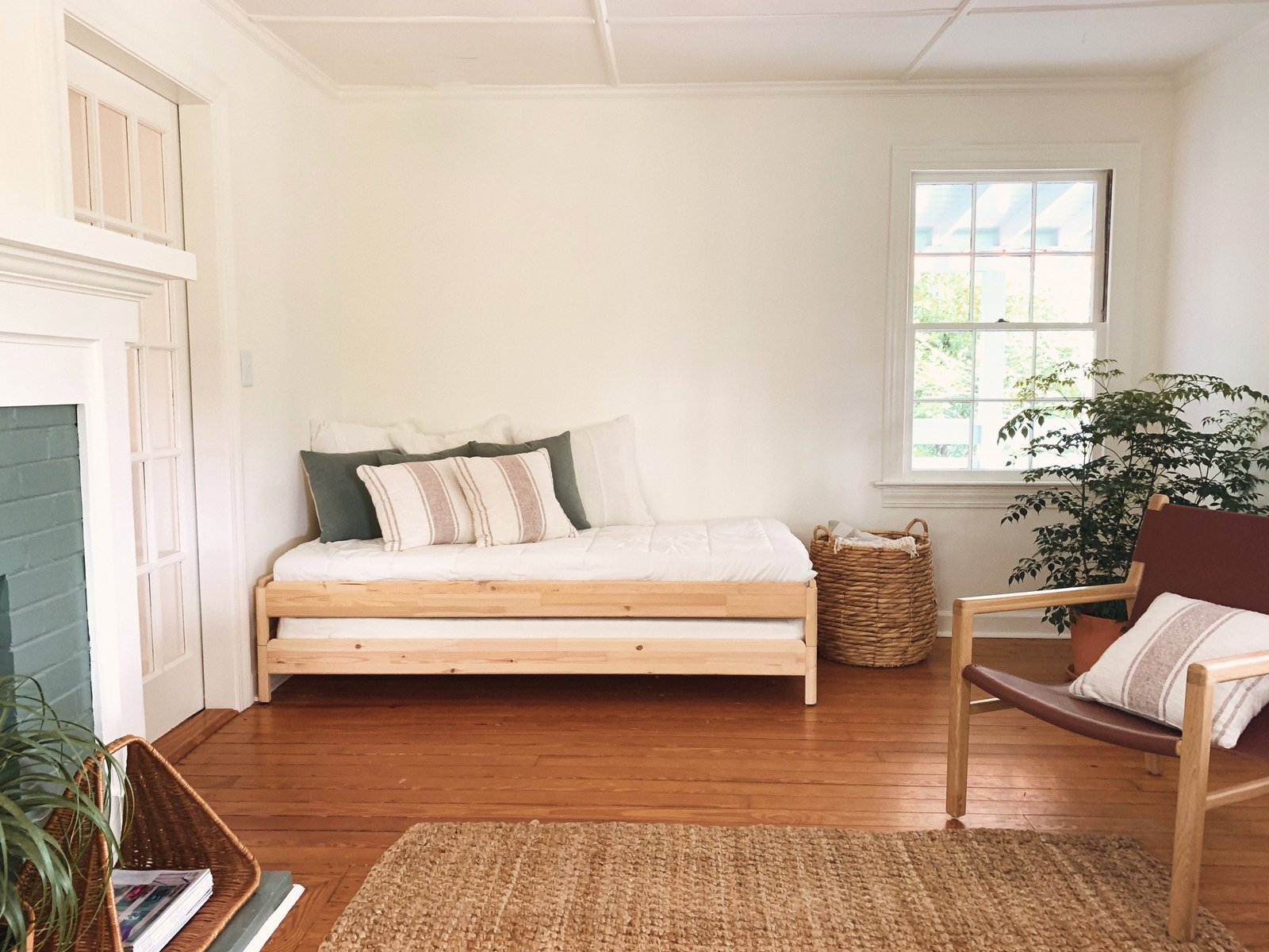 Extra bedroom with single bed, laundry basket, and a simple living chair.