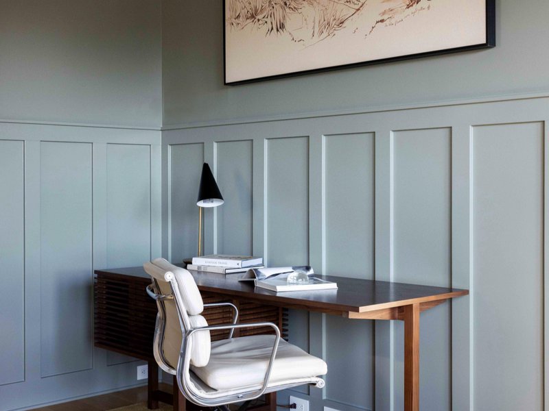 Study room with blue wall panels, a desk, and a chair